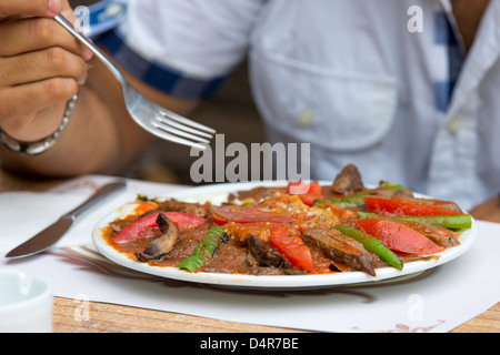 Immer bereit, Türkisch Iskender-Döner essen, garniert mit Rindfleisch-Streifen, in Scheiben geschnittene Tomaten und Paprika. Stockfoto