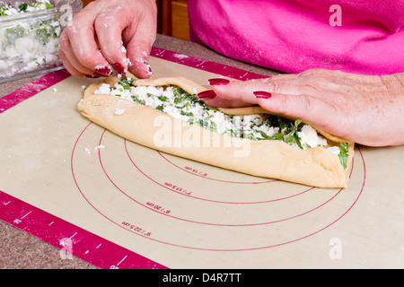 Ältere Dame Hände wickeln türkischen Feta Käse Pide Taschen. Stockfoto