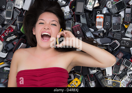 Frau oben auf einem Stapel von mobile-Handys Stockfoto