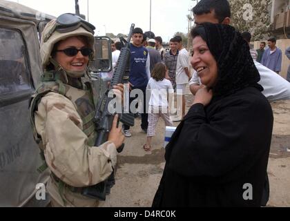 US Marine-Soldat Sergeant Maykate Linanne spricht eine irakische Frau am 13. April 2003 in Bagdad. Stockfoto