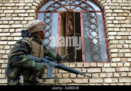 Ein US-Soldaten des 3. Light Armored Reconnaissance Bataillons der US-Marine Infanterie stürmt ein Regionalbüro der Baath-Partei am 2. April 2003, ca. 90 km südlich von Bagdad. Stockfoto