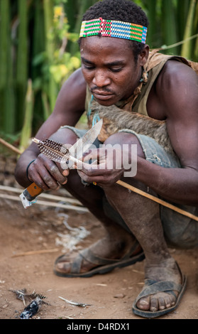 Hadzabe Jäger making Pfeile Stockfoto