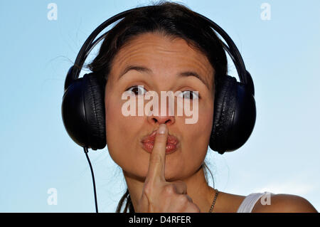 (dpa-DATEI) - ein Archivbild vom 25. September 2011 zeigt eine Abbildung einer jungen Frau, die ein Headset trägt, während sie einen Finger an ihren Mund hält, was darauf hinweist, dass sie in Berlin, Deutschland, ruhig ist. Fotoarchiv für Zeitgeschichte () Stockfoto