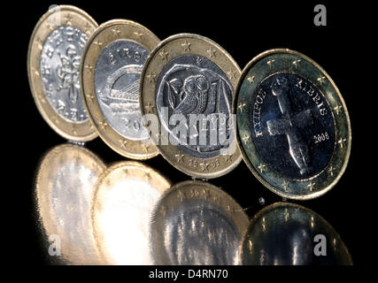 (ABBILDUNG) Eine Abbildung vom 18. März 2013 zeigt eine zypriotische Euro-Münze (R) neben Euro-Münzen aus Portugal (L-R), Irland und Griechenland sitzt auf einem Tisch in Köln, Deutschland, 18. März 2013. Nach Monaten des Streits hat die EU ein Hilfspaket für Zypern vereinbart. Foto: Oliver Berg Stockfoto