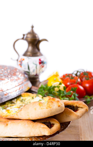 Mit Käse und erfahrene Boden Rindfleisch türkische Pide garniert mit Zitrone, Petersilie und Tomaten an den Rebstöcken gemacht. Serviert mit ayran Stockfoto