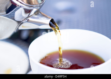 Gießen heißen schwarzen Tee aus Restaurant Stil Rinder. Selective konzentriert sich auf Wasserkocher und Tee gegossen. Stockfoto