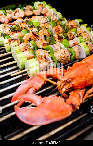 Lachs-Spieße und Hummer sind auf dem Grill. Stockfoto