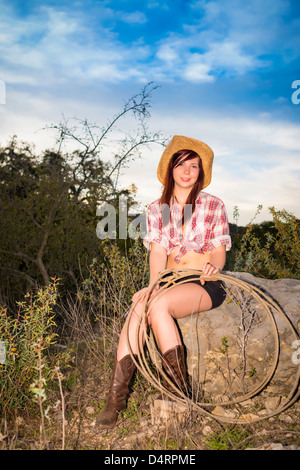 Porträt der jungen Frau mit Seil, im lässigen Cowgirl Outfit Cowboy Hut, Weiblich 19 kaukasischen, Texas, USA Stockfoto