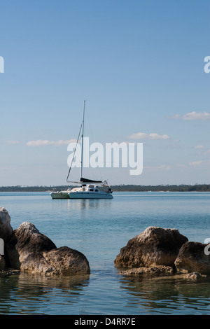 Wellenbrecher mit Segelboot im Hintergrund. Stockfoto