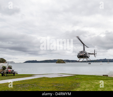 ZK-HGM New Zealand Registrierung schwarze Hubschrauber Robinson R44 Raven II kommen, um auf Hubschrauberlandeplatz landen. Stockfoto