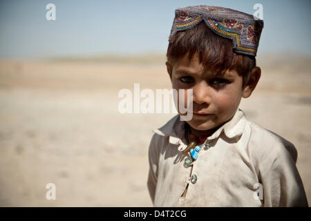 Ein afghanischer Junge Uhren National Army Special Forces ein Distrikt-Governor 17. März 2013 in der Provinz Helmand, Afghanistan abzusichern. Stockfoto