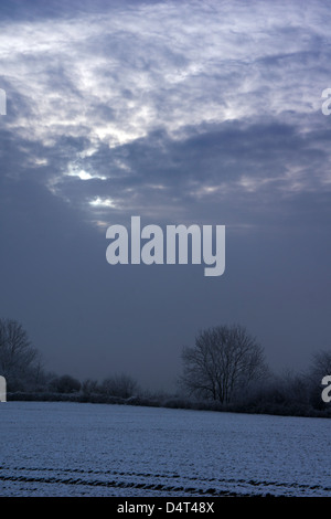 Winterszenen rund um Doncaster mit einem schneebedeckten Steinhaus, einer Person, die durch einen frostigen Waldweg geht, und Fußspuren über verschneite Fälle Stockfoto