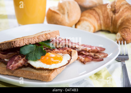 Gebratenes Ei-Sandwich mit Speck auf einem Teller Stockfoto