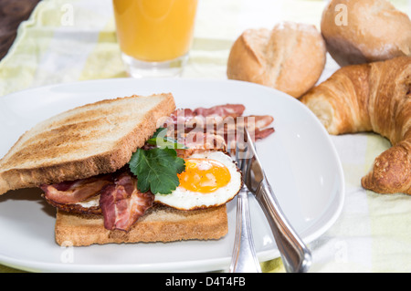 Gebratenes Ei-Sandwich mit Speck auf einem Teller Stockfoto