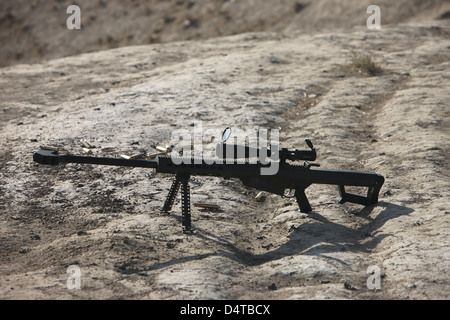 Das Scharfschützengewehr Barrett M82A1 und verbrauchte Patronen auf einem Wadi in Nordafghanistan. Stockfoto