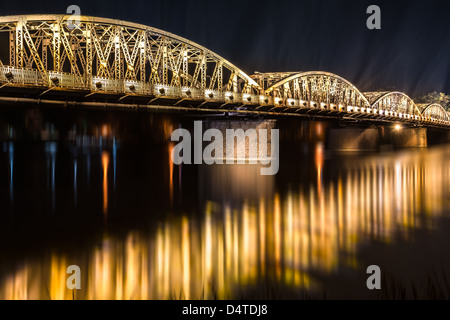 Panoramablick auf Stadt Hue Truong Tien Brücke in der Nacht. Brücke mit verschwommenen Spiegelbild auf dem Wasser überall beleuchtet. Spalten Stockfoto