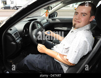 Christian Kandlbauer, Inhaber von zwei Arm Prothesen, steuert eine maßgeschneiderte Auto mit Automatikgetriebe in Berlin, Deutschland, 13. November 2009. Eine neue Generation gedankenkontrollierte Arm Prothese auf seinem linken Arm steuert die Anzeige und die Hupe. Die Muskel-gesteuerte Prothesen an seinem rechten Arm betreibt das Lenkrad. Die gedankenkontrollierte Arm-Prothese ist ein Prototyp von Otto Stockfoto