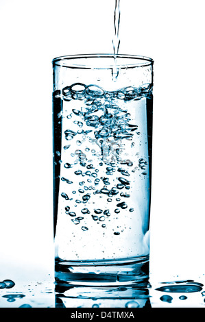 Kaltes Wasser in ein Glas gegossen wird. Stockfoto