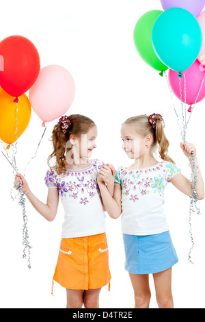 Zwei Mädchen mit bunten Ballons in Händen. Isoliert auf weiss. Stockfoto