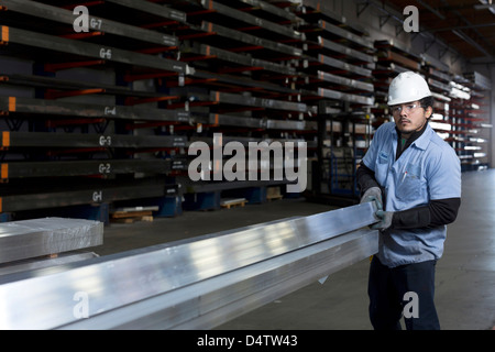 Arbeiter halten Metall im Werk Stockfoto