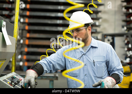Arbeiter am Bedienfeld in Metall-Anlage Stockfoto