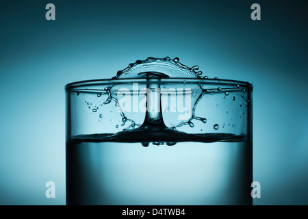 Tropfen Sie in Glas Wasser plantschen Stockfoto