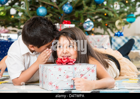 Kinder Flüstern Weihnachtsbaum Stockfoto