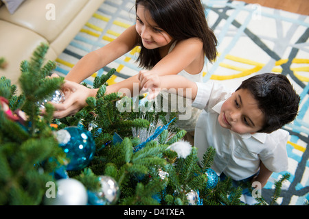 Kinder schmücken Weihnachtsbaum Stockfoto