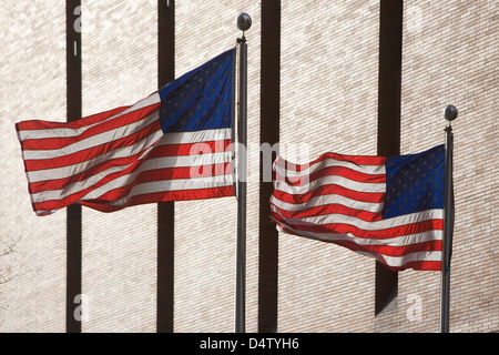 Amerikanische Flaggen von Wolkenkratzer fliegen Stockfoto
