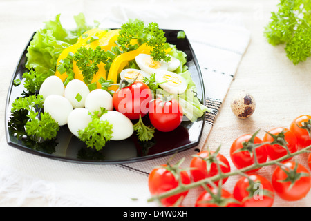 Salat mit frischem Gemüse und Wachteleier auf einer quadratischen Platte, Cherry Tomaten Stockfoto