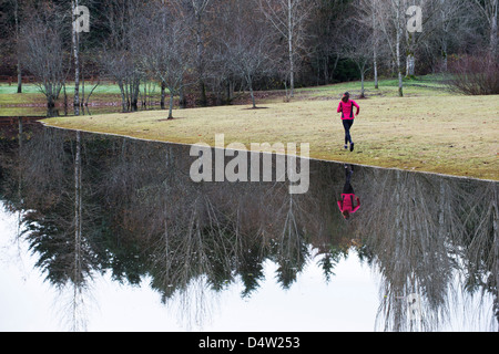 Frau läuft noch ländliche See Stockfoto