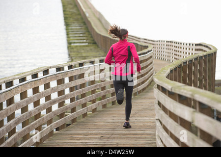 Frau, die auf hölzernen dock Stockfoto