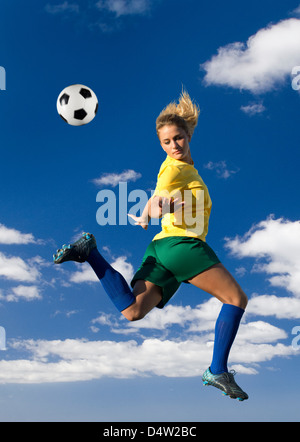 Fußball-Spieler treten in der Luft Stockfoto