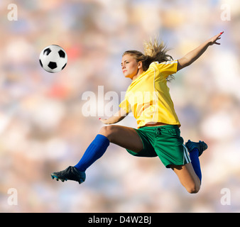 Fußball-Spieler treten in der Luft Stockfoto