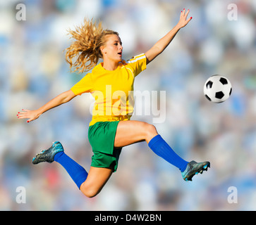 Fußball-Spieler treten in der Luft Stockfoto