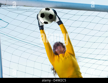 Fußball-Spieler fangen Ball im Tor Stockfoto