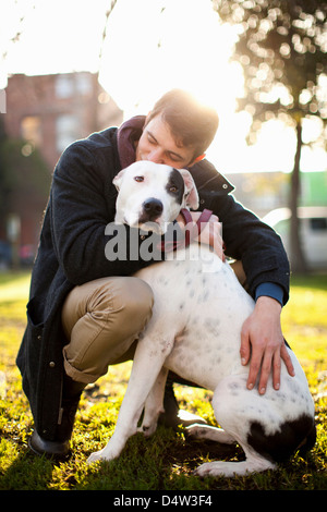 Mann umarmt Hund im park Stockfoto