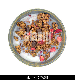Eine Portion Müsli mit Erdbeer und Schokolade Stücke in eine alte Schüssel mit Magermilch. Stockfoto