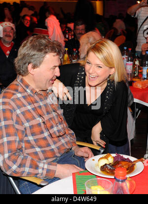 Actress Jeanette Biedermann (R) serviert Mahlzeiten während der traditionelle Weihnachts-Charity-Dinner für Obdachlose im Hotel Estrel in Berlin-Neukölln, Deutschland, 21. Dezember 2009. Prominente serviert Mahlzeiten, einige 2,700 Gäste bei der diesjährigen Charity. Abgesehen von gebratenen Gänsen und Bier wurden decken, Schlafsäcke und warme Kleidung an bedürftige ausgehändigt. Sänger Frank Zander "Diakonische Stockfoto