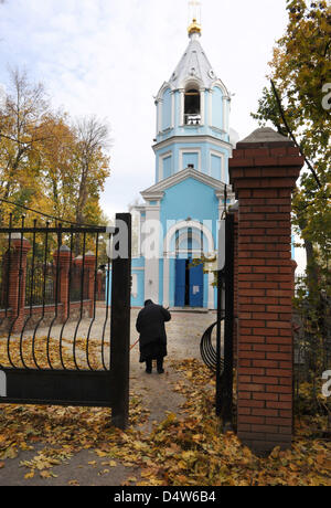 Eine alte Frau fegt Blätter auf dem Innenhof des Friedhofs in Kursk, Russland, 16. Oktober 2009. Foto: Uwe Zucchi Stockfoto