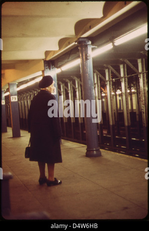 Eine Frau wartet auf einen Zug an der 79th Street Station. 05/1973 Stockfoto