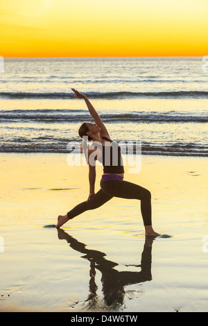 Frau praktizieren Yoga am Strand Stockfoto