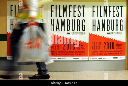 Ein Fußgänger geht Plakate der 18. Filmfest Hamburg in Hamburg, Deutschland, 14. September 2010. Das Festival soll mit sechs Filme die Beatles, denken Sie daran, die ihre Weltkarriere vor 50 Jahren in der Hansestadt begann. Damit ist die Polizei-Domcumentation "Ankunft der Beatles in Hamburg" von 1966 zum ersten Mal der Öffentlichkeit präsentiert. 18. Hamburg Film Stockfoto