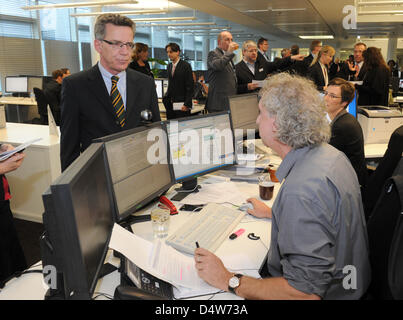 Bundesinnenminister Thomas de Maizière (CDU-L) im Gespräch mit Redakteur Verantwortlichen Froben Homburger in der neuen zentrale Redaktion der deutschen Presse-Agentur Dpa in Berlin, Deutschland, 15. September 2010. Zum ersten Mal in der Geschichte des DSG hat die größte deutsche Presse-Agentur seine zentralen Redaktionen in einer Nachrichtenredaktion zusammengebracht. Mehr als zwei Dutzend editori Stockfoto
