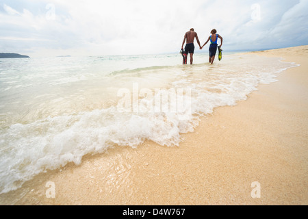 Paare, die am tropischen Strand Stockfoto