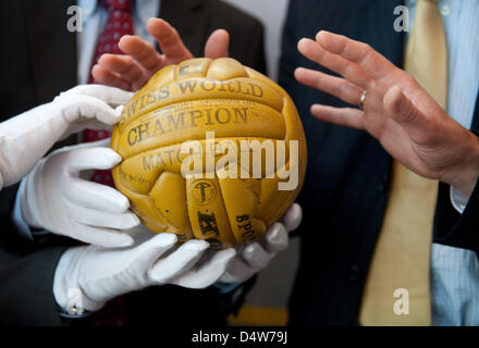 Direktor der Stiftung Fußballmuseum der deutschen Fußball-Bundes, Manuel Neukirchner (L) und der Generalsekretär des DFB, Wolfgang Niersbach, den ursprünglichen Ball des WM-Endspiels von 1954 nach einer Pressekonferenz in Dortmund, Deutschland, 16. September 2010 präsentieren. Die Stiftung stellte Konzepte über das Fußball-Museum Stockfoto