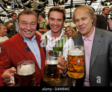 Sänger Karel Gott (L-R), TV-Moderator Florian Silbereisen und französische Pianist Richard Claydermann mit einer Masse von Bier als das Oktoberfest 2010 stellen startet in München, Deutschland, 18. September 2010. Das weltweit größte Volksfest findet statt vom 18. September bis zum 3. Oktober 2010 zum 177. Mal. Es wurde zum ersten Mal anlässlich der Hochzeit vor 200 Jahren gefeiert. Stockfoto