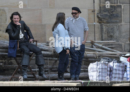 Während der Dreharbeiten für eine Neuverfilmung des klassischen "die drei Musketiere" nimmt britischer Schauspieler Luke Evans (L) eine Auszeit am Set in Bamberg, Deutschland, 24. September 2010. Foto: DAVID EBENER Stockfoto