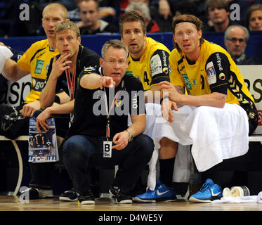 Cheftrainer Gudmundur Gudmundsson (C) spricht mit seinen Spielern Boerge Lund (R), Oliver Roggisch (2-R) und Karol Bielecki Gesten an der Seitenlinie während der Handball Bundesliga Spiel HSV Hamburg gegen Rhein-Neckar Löwen in der 02 World in Hamburg, Deutschland, 24. November 2010. Foto: Marcus Brandt Stockfoto