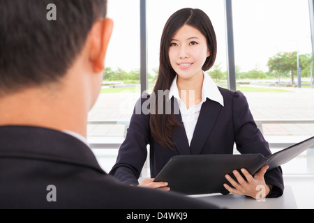 lächelnde Geschäftsfrau Interviews mit Geschäftsmann im Büro Stockfoto